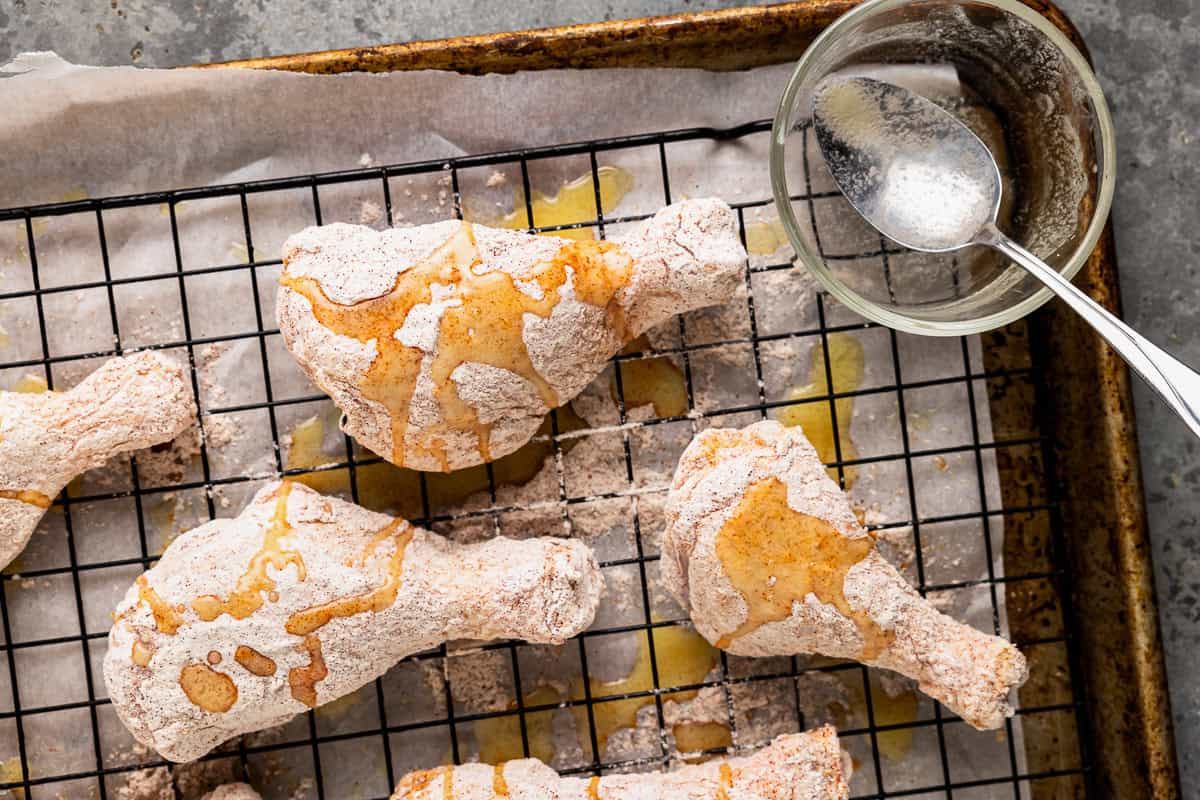 Flour-coated drumsticks drizzled with melted butter.