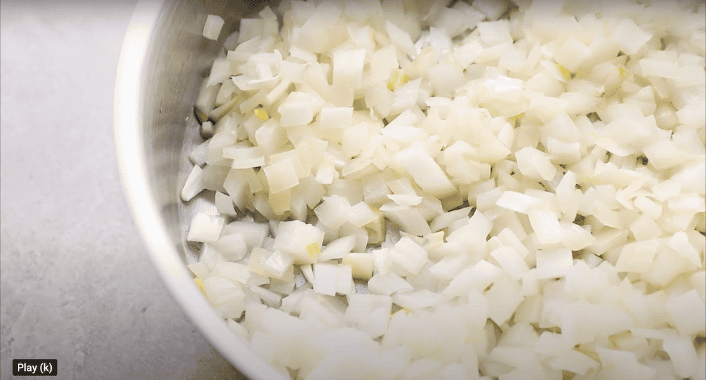 Diced onions cooking in a pan.
