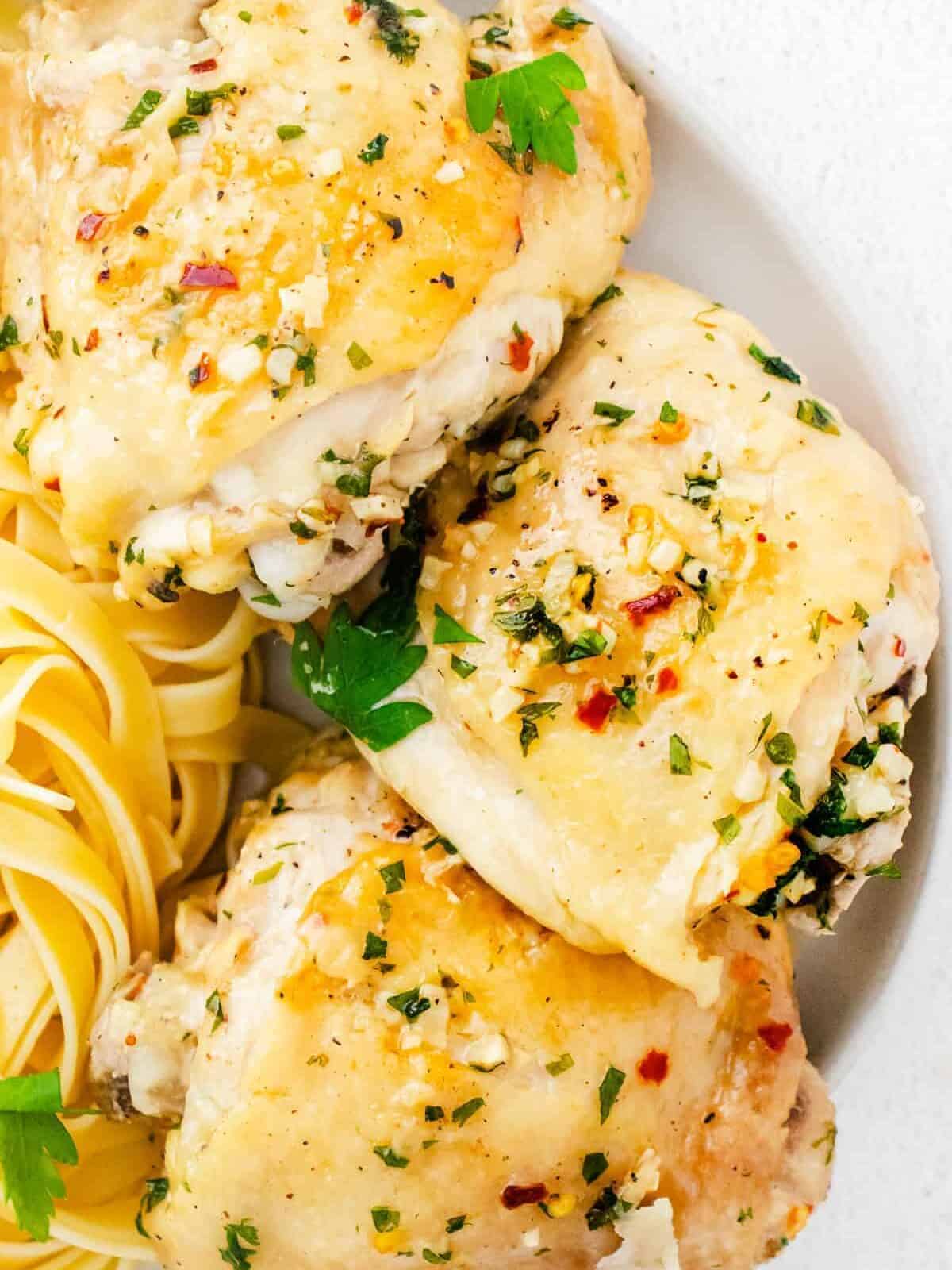 garlic parmesan chicken thighs on plate with pasta
