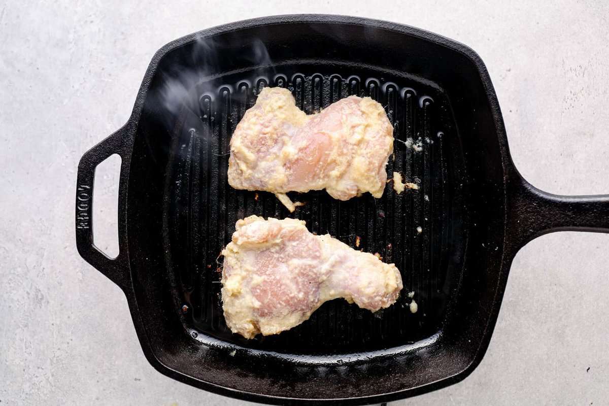 Vietnamese marinated chicken cooking on a grill pan.