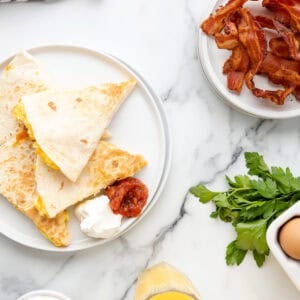 overhead view of breakfast quesadillas on a white plate.