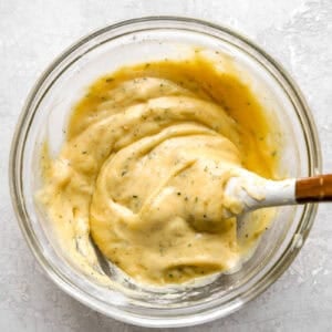 creamy ranch sauce in a glass bowl with a rubber spatula.