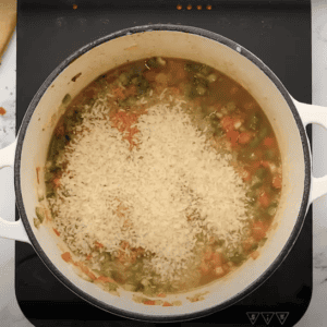 Jambalaya mixture with grains of rice in a large pot.