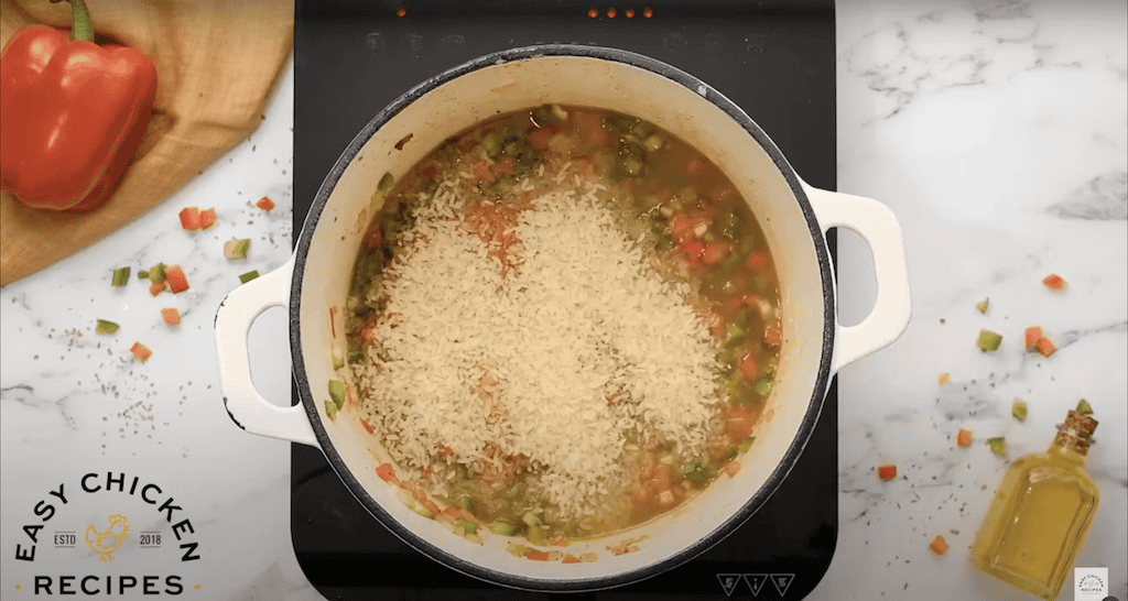 Jambalaya mixture with grains of rice in a large pot.