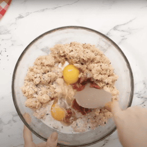 Combining ground chicken mixture with eggs and tomato paste.