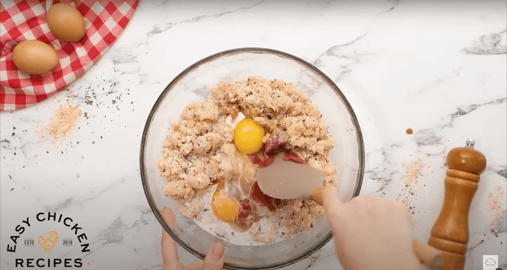 Combining ground chicken mixture with eggs and tomato paste.