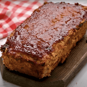 Baked chicken meatloaf on a cutting board.