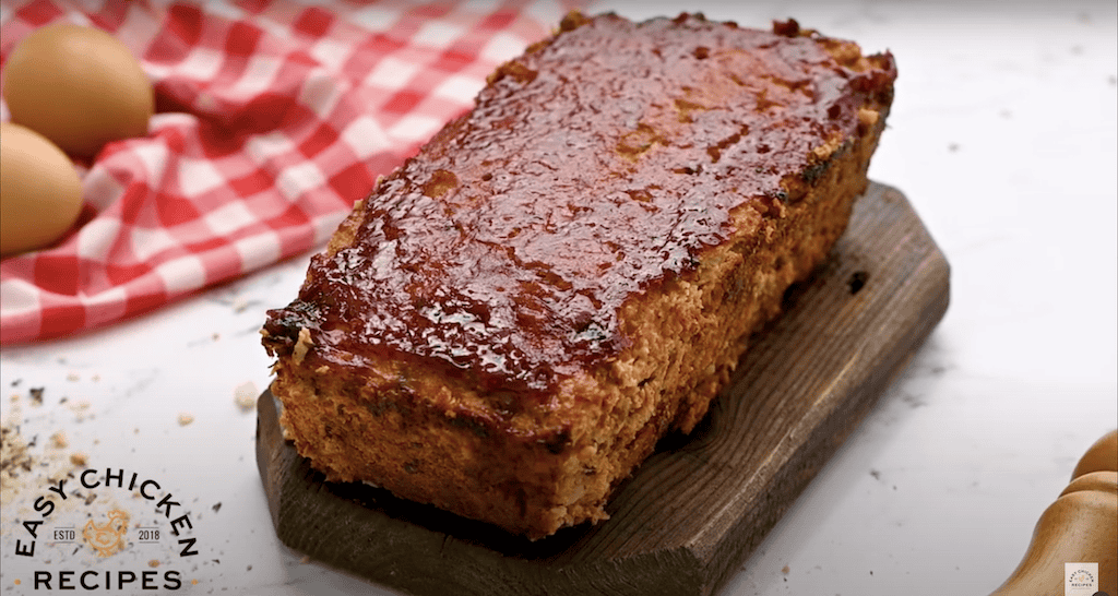 Baked chicken meatloaf on a cutting board.