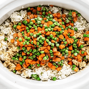 frozen mixed veggies over cooked white rice in a crockpot.