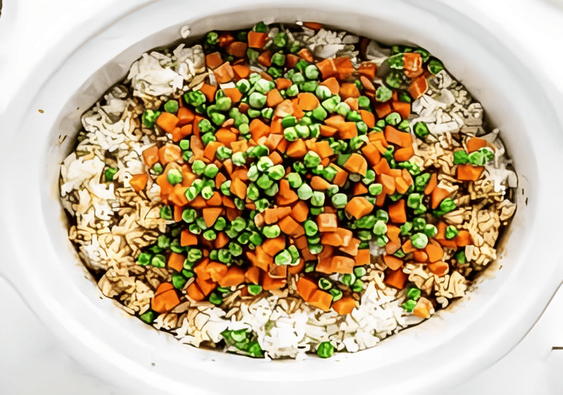 frozen mixed veggies over cooked white rice in a crockpot.