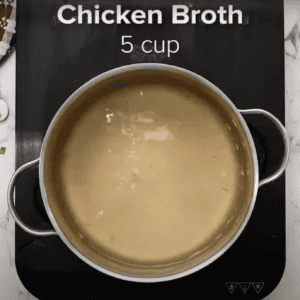 A large pot filled with chicken broth.