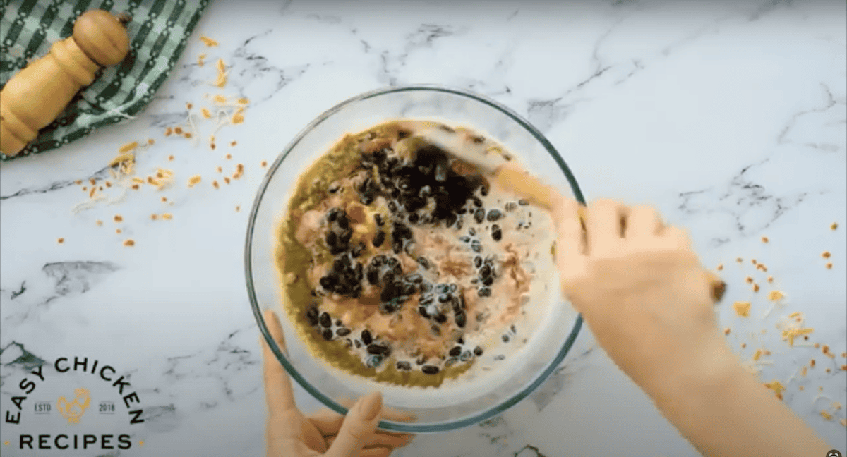 Combining ingredients in a glass mixing bowl.