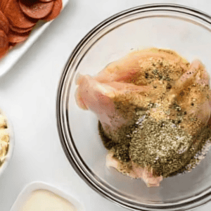 seasoned chicken breasts in a glass bowl.