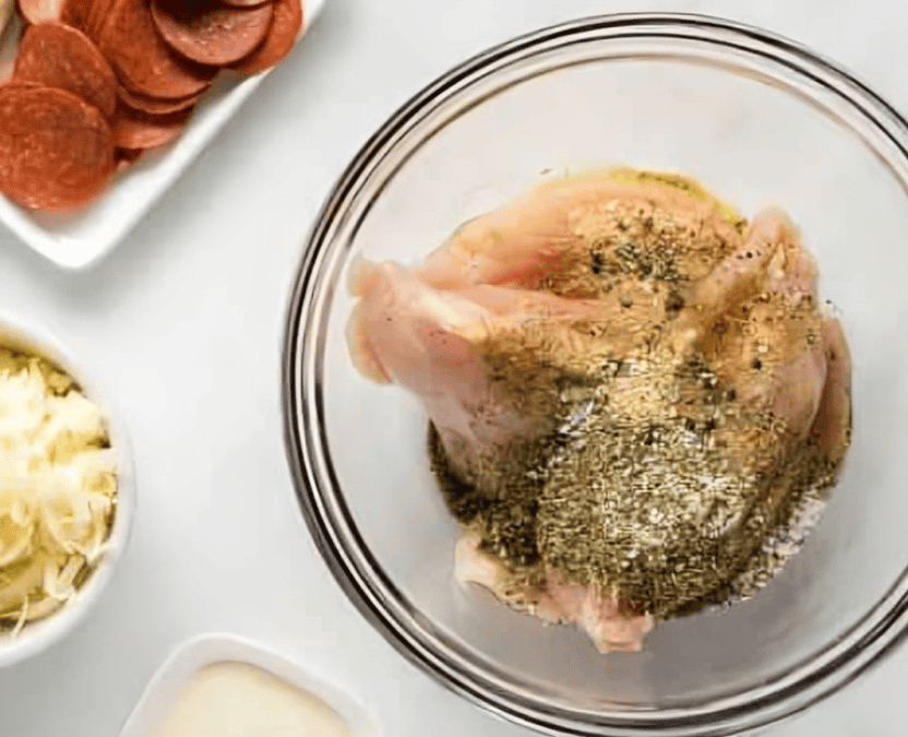 seasoned chicken breasts in a glass bowl.