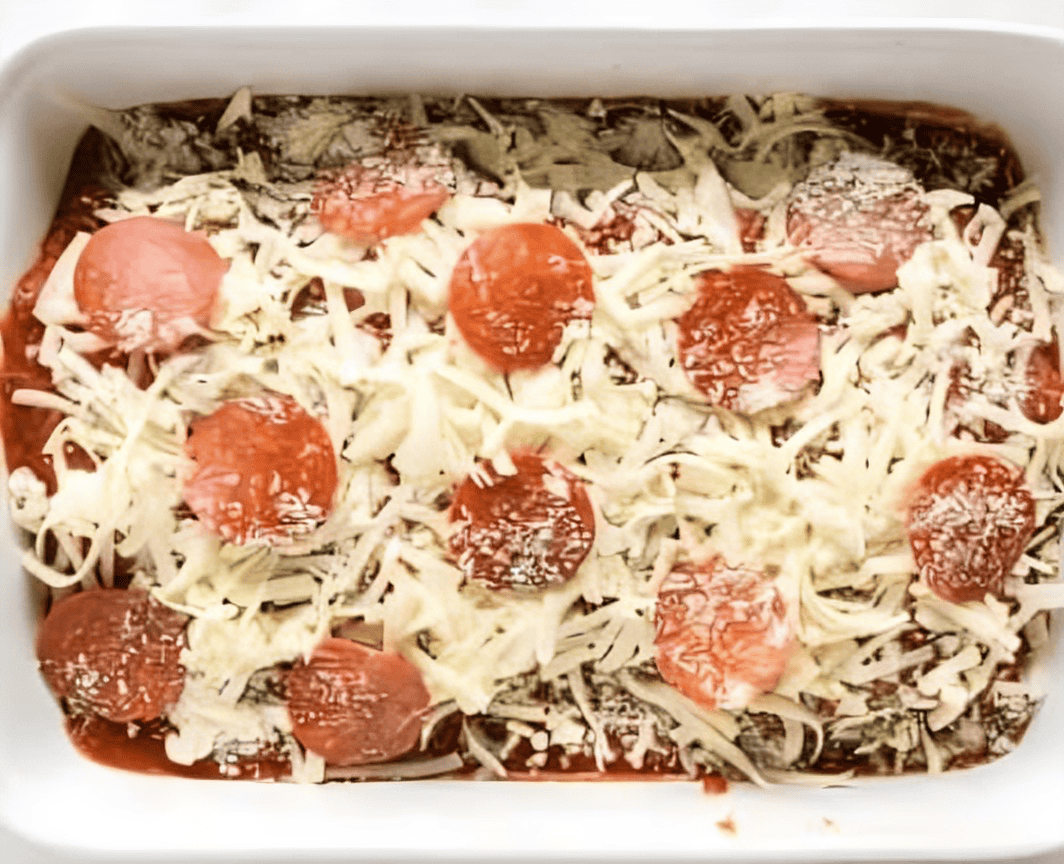 stuffed chicken breasts topped with cheese and pepperoni in a baking pan.