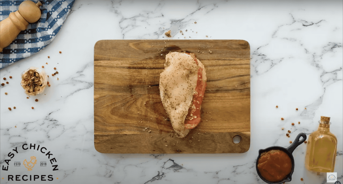 A chicken breast stuffed with pepperoni and mozzarella, on a cutting board.