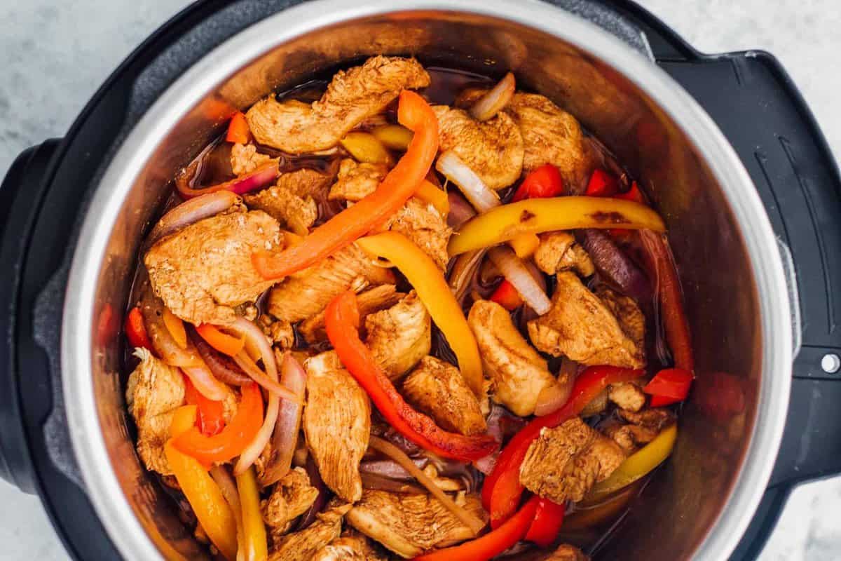 Chicken fajita filling (strips of chicken, bell peppers, and onions) in an Instant Pot.
