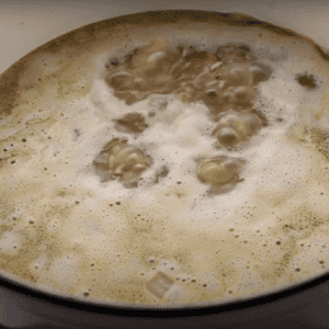 Chicken broth boiling in a pot.