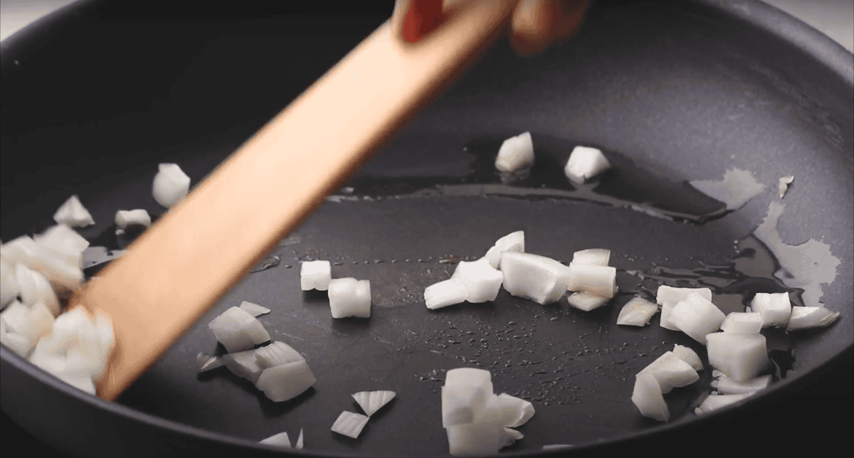 Diced onions cooking in a pan.