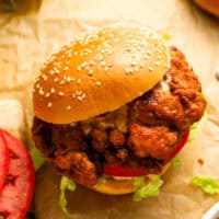 a spicy chicken sandwich on parchment paper.