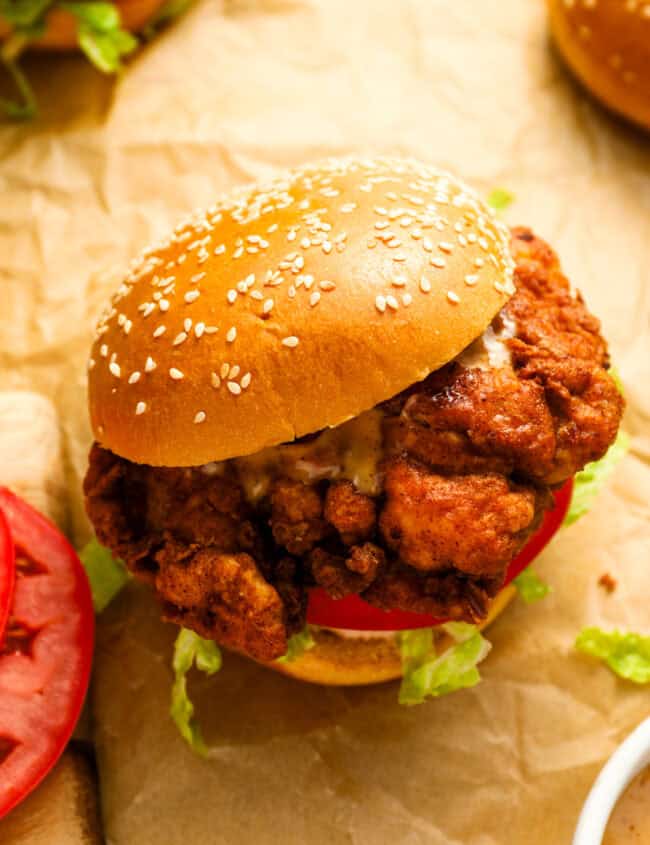 a spicy chicken sandwich on parchment paper.