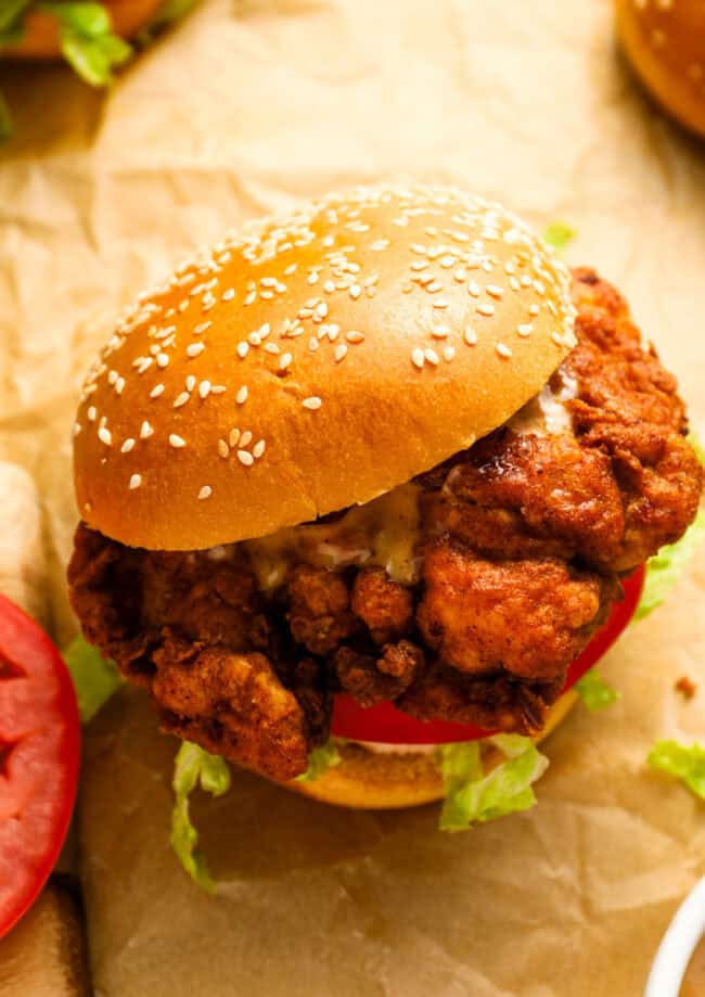 a spicy chicken sandwich on parchment paper.