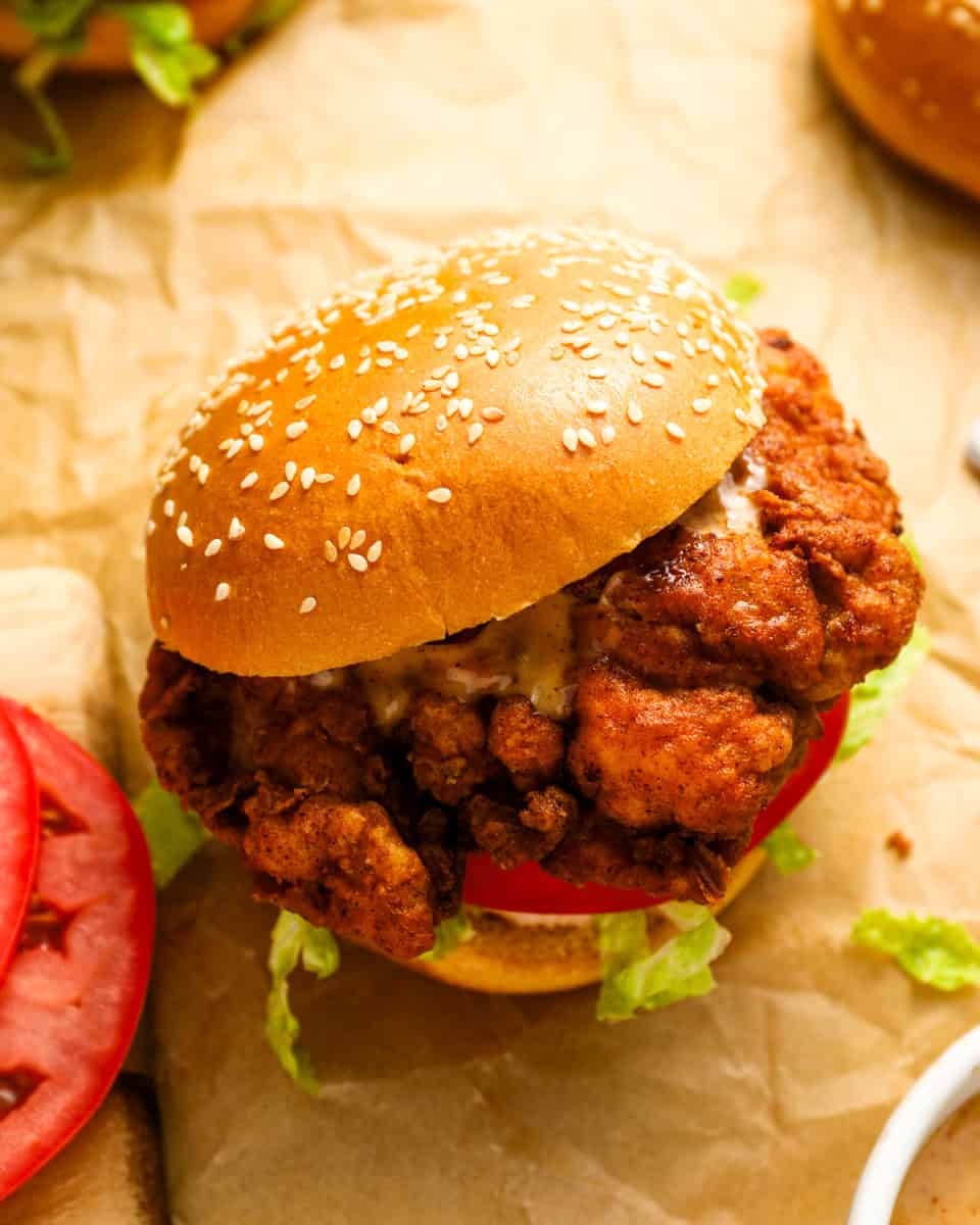 a spicy chicken sandwich on parchment paper.