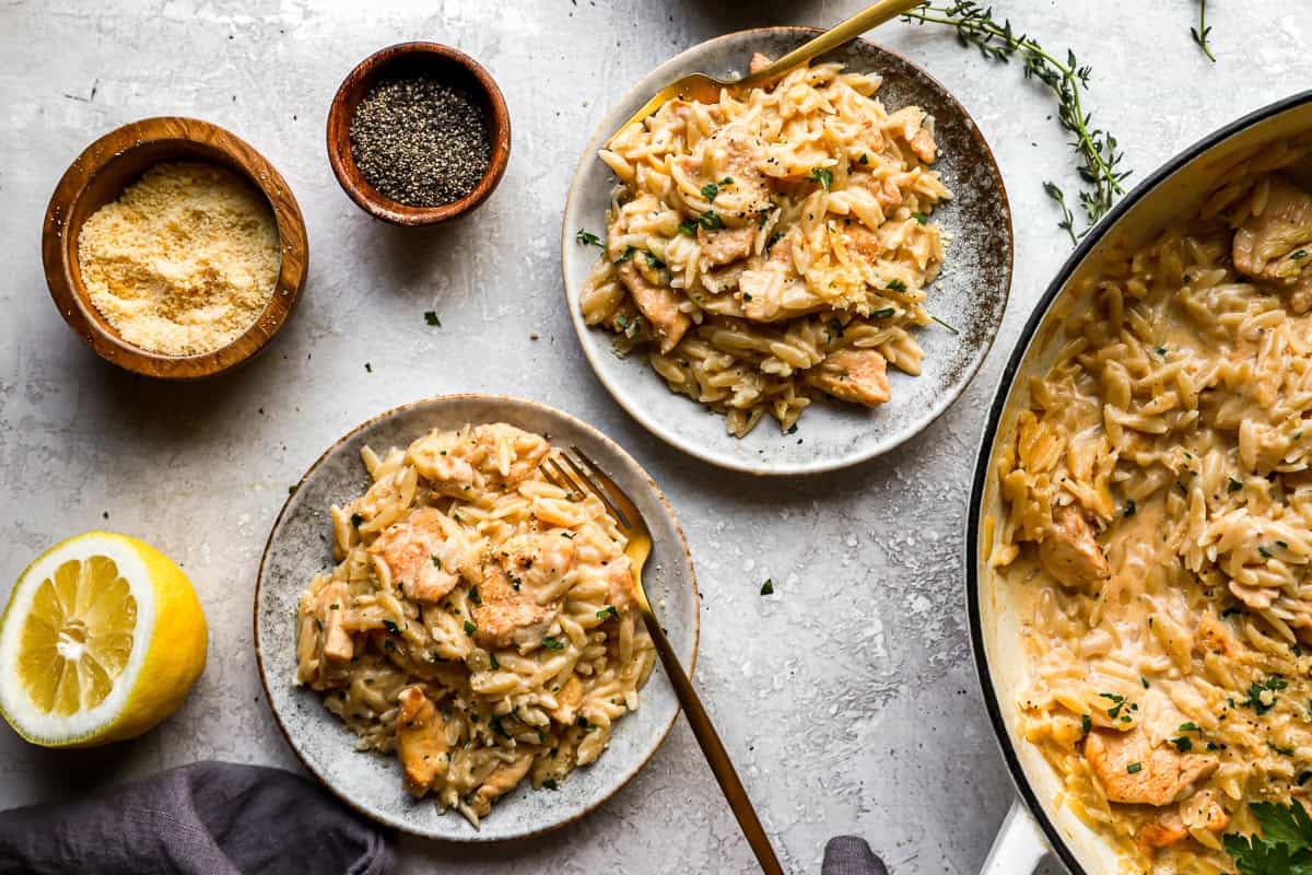 overhead view of 2 plates of creamy chicken orzo.