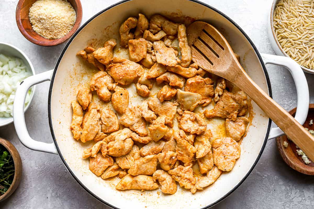 cooking chicken pieces in a pan.