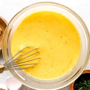 whisking eggs in a glass bowl.