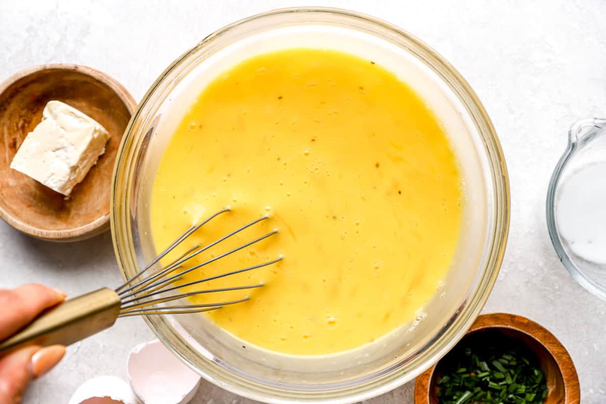 whisking eggs in a glass bowl.