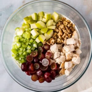 waldorf chicken salad ingredients in a glass bowl.