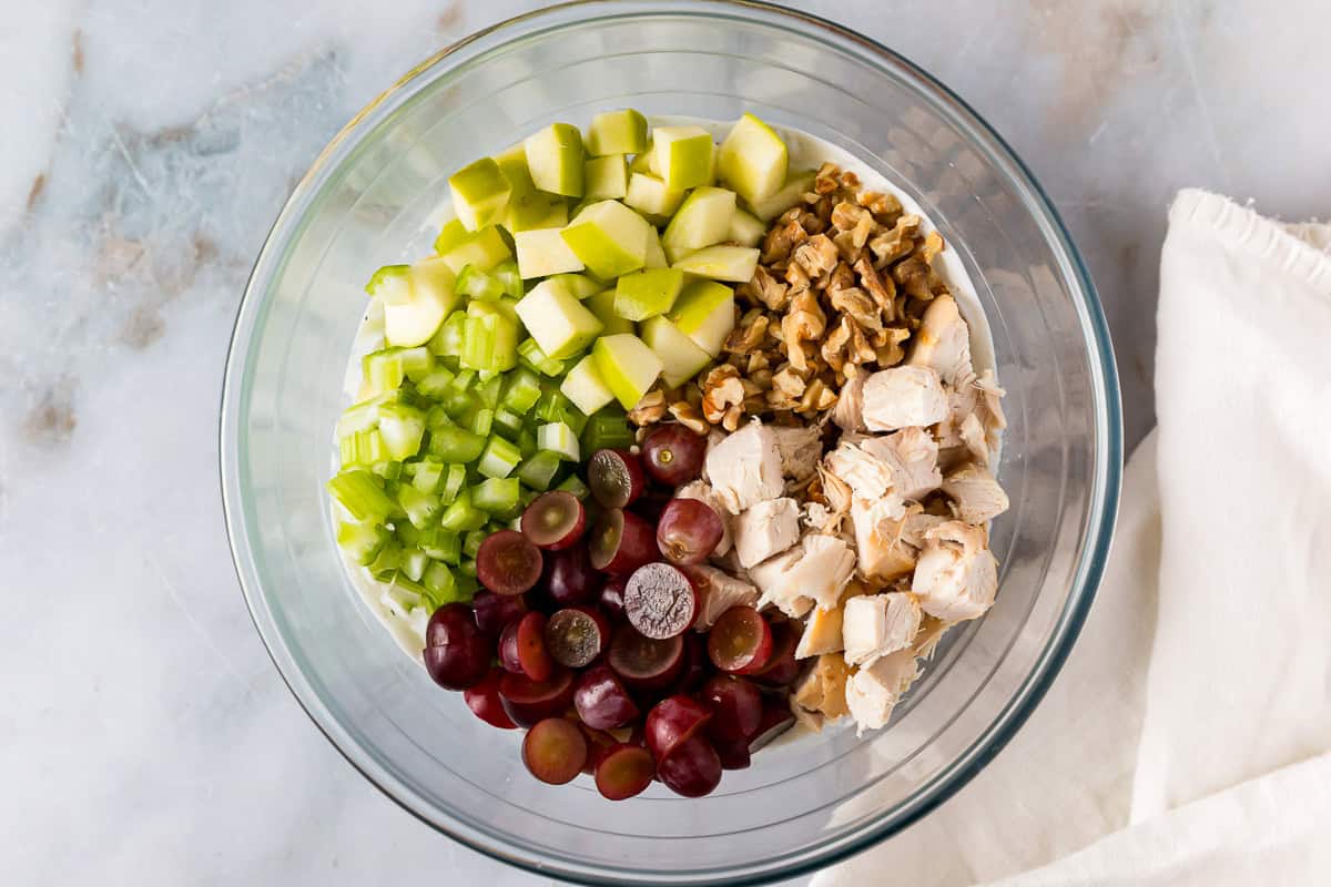 waldorf chicken salad ingredients in a glass bowl.