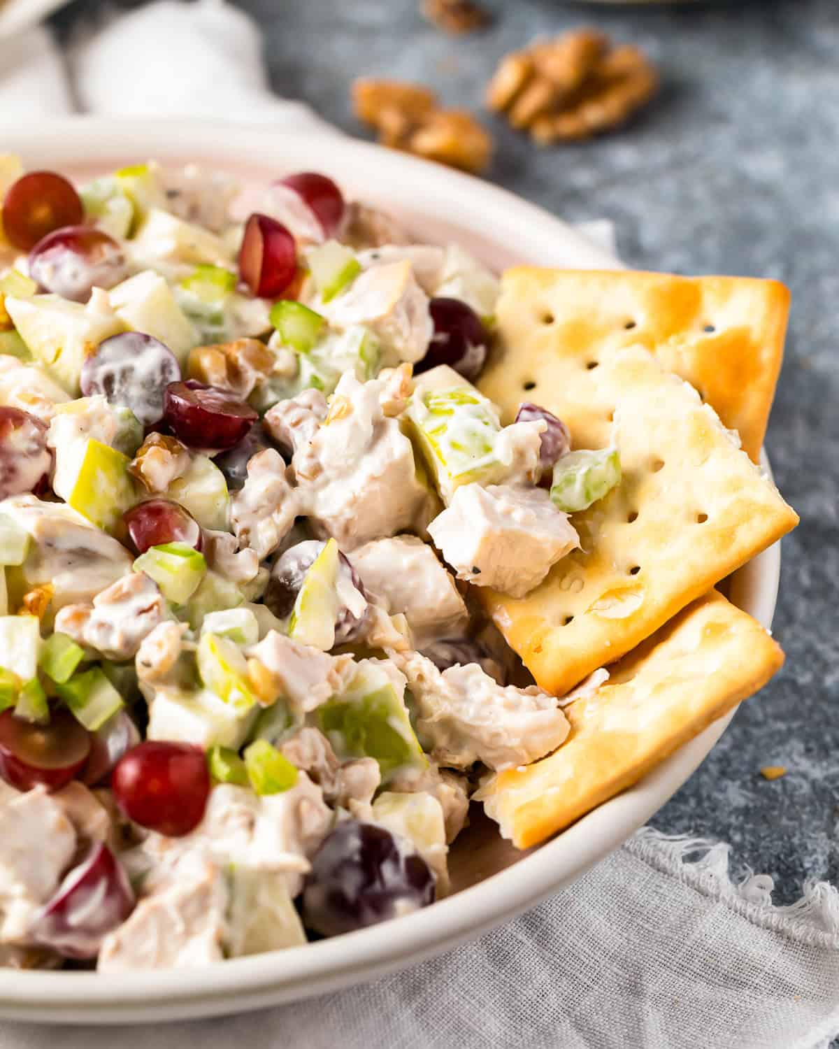 waldorf chicken salad in a bowl with crackers.