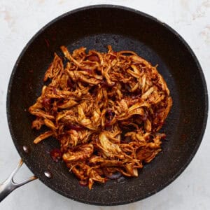 bbq shredded chicken and onions in a pan.