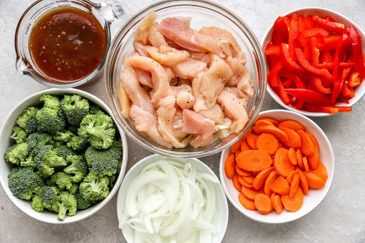 Ingredients for chicken teriyaki stir fry arranged in bowls.