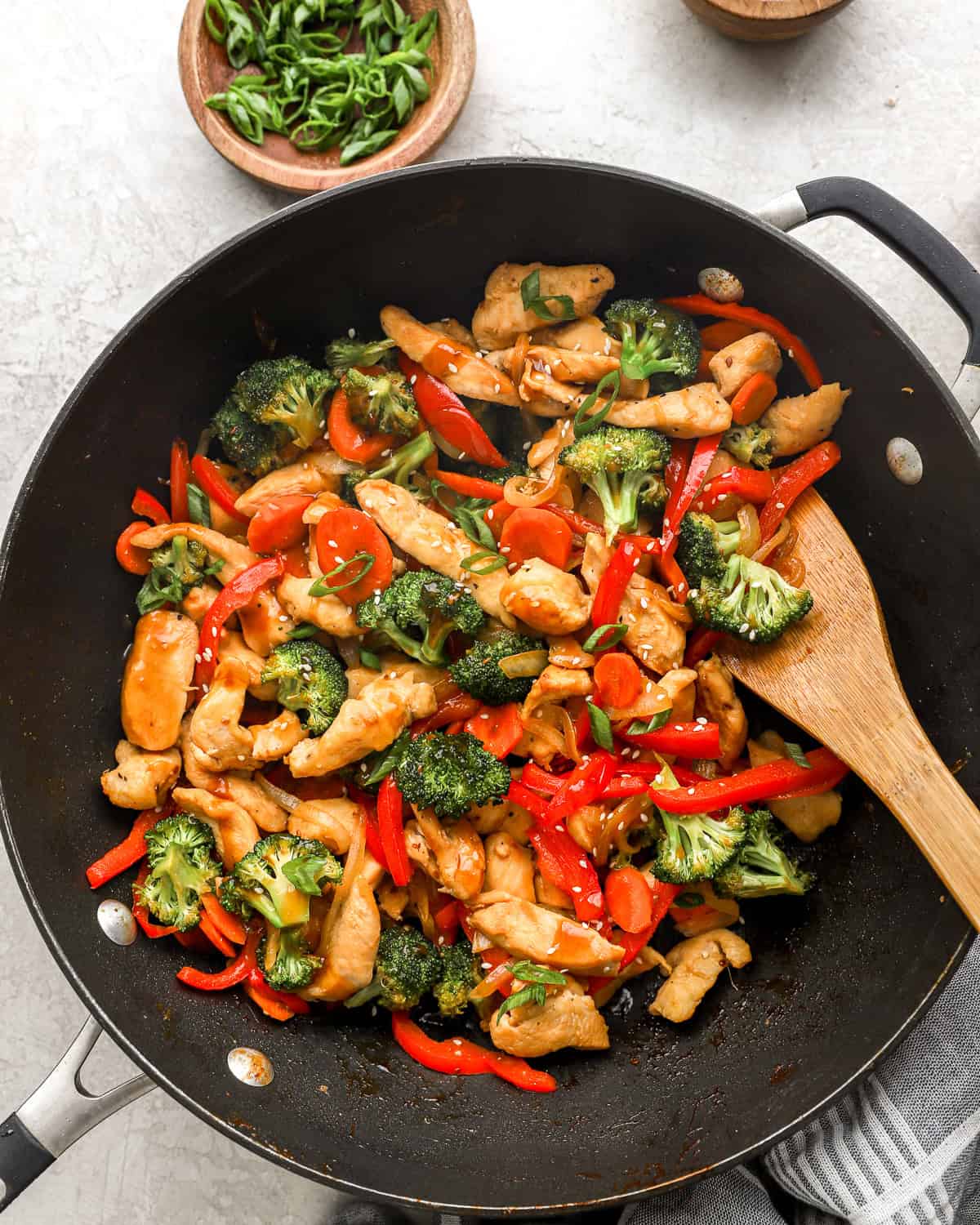 Chicken teriyaki stir fry with veggies cooking in a skillet.