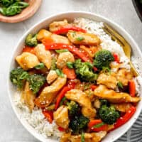 Overhead view of a bowl of chicken teriyaki stir fry with white rice.