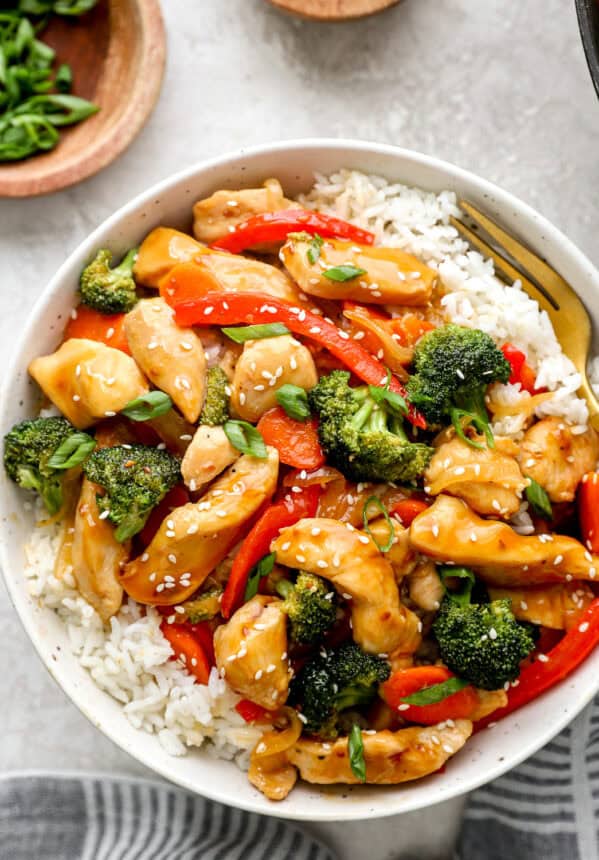 Overhead view of a bowl of chicken teriyaki stir fry with white rice.