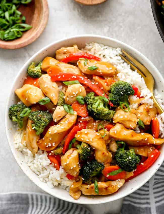 Overhead view of a bowl of chicken teriyaki stir fry with white rice.