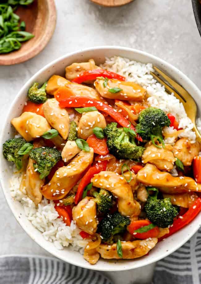 Overhead view of a bowl of chicken teriyaki stir fry with white rice.