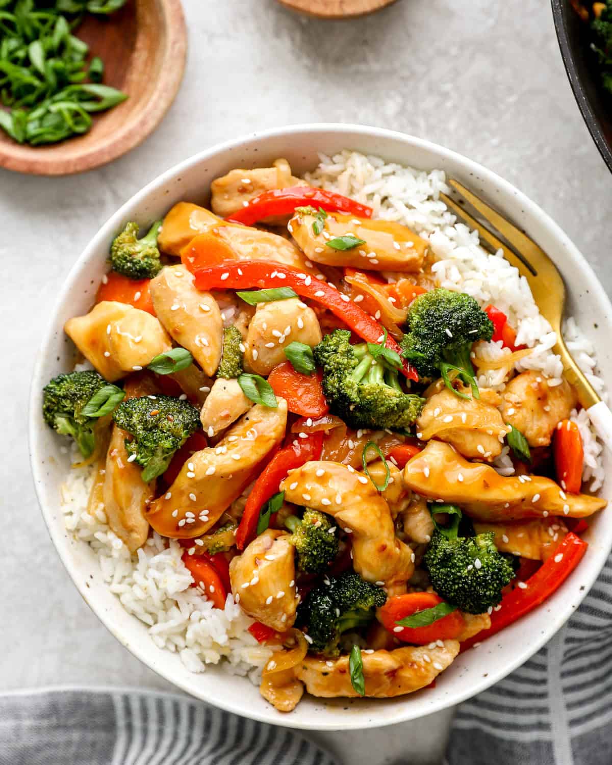 Overhead view of a bowl of chicken teriyaki stir fry with white rice.