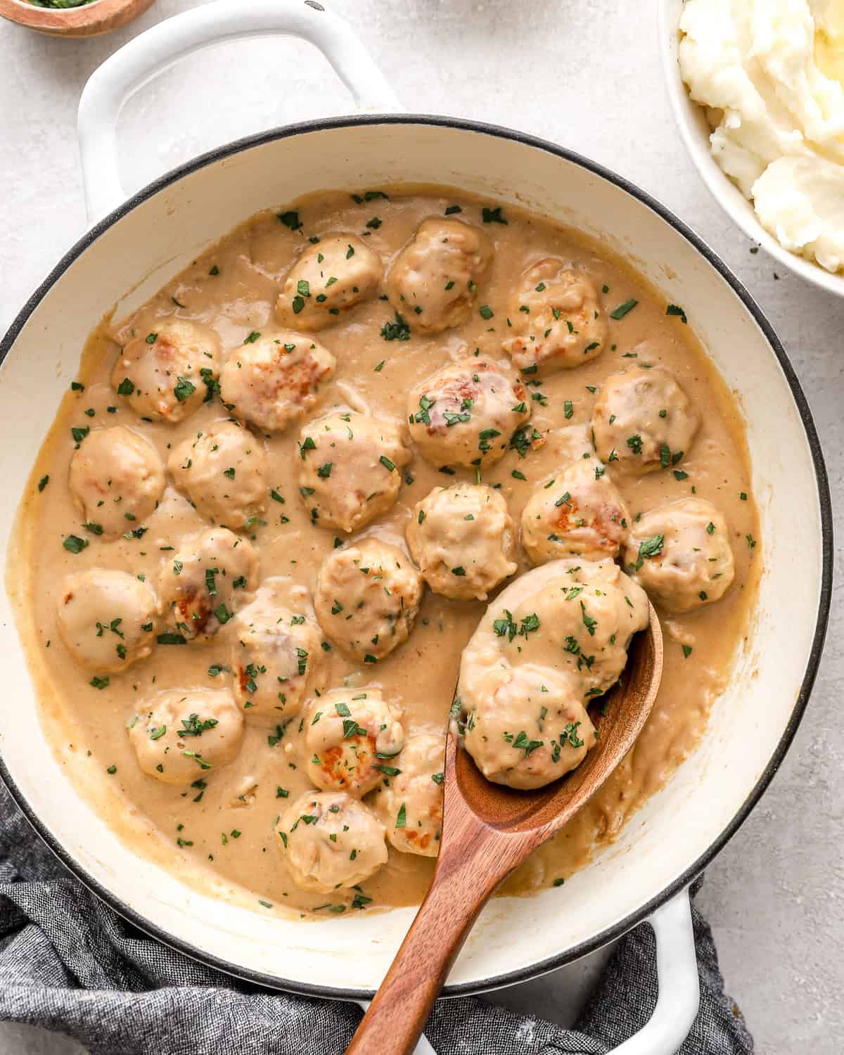 Swedish chicken meatballs in sauce in a large pot.