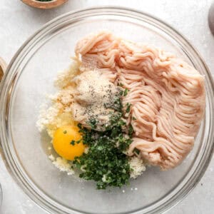 Ground chicken, egg, breadcrumbs, and herbs in a mixing bowl.