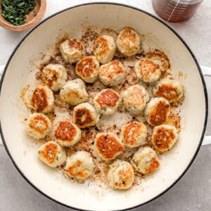 Ground chicken meatballs in a pot.