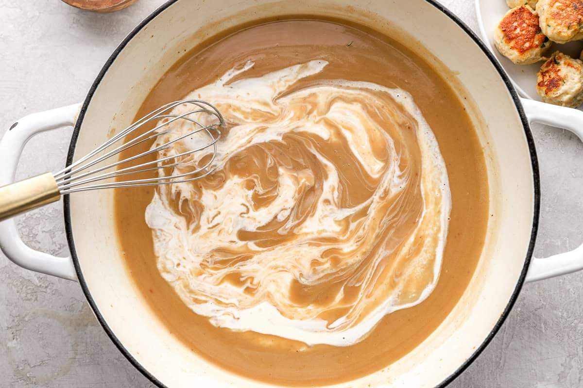 Whisking cream into a sauce.