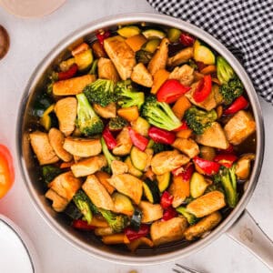 honey soy chicken stir fry in a pan.