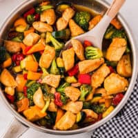 overhead view of honey soy chicken stir fry in a pan with a spoon.