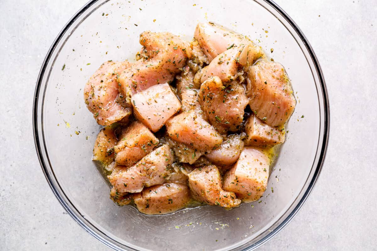 Cubes of chicken in an olive oil marinade.