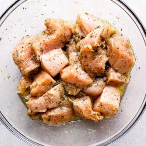 Cubes of chicken in an olive oil marinade.